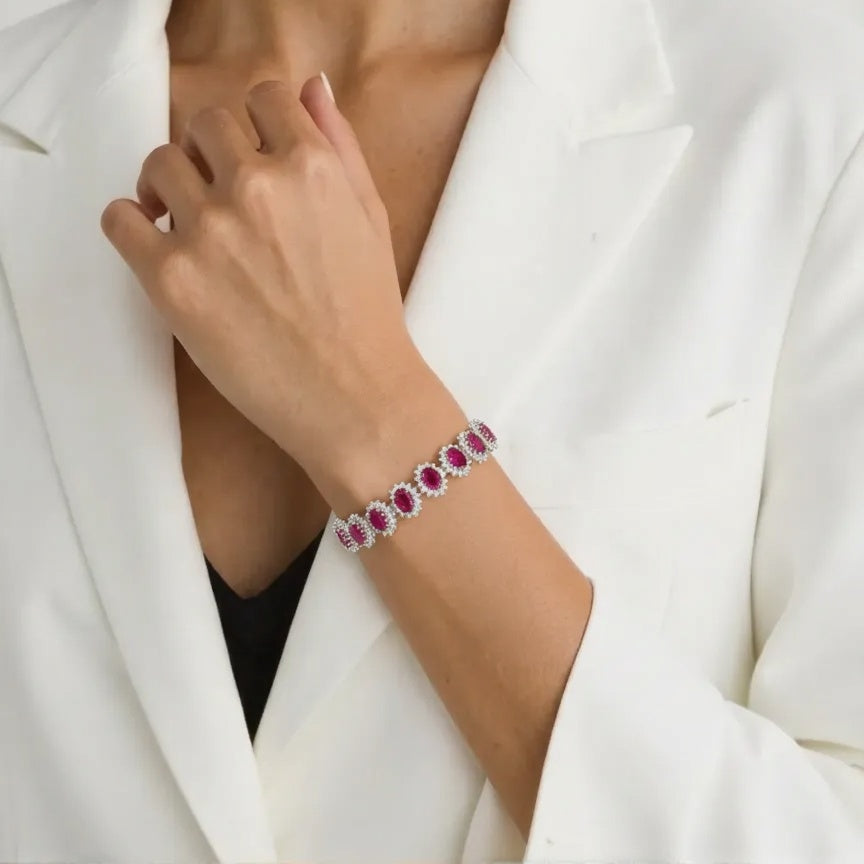 Bracelet with red gemstones on a person wearing a white blazer