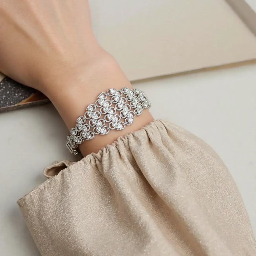 Silver bracelet on a wrist with a neutral background