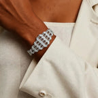 Silver bracelet on a wrist with a beige coat background