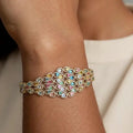 Multicolored gemstone bracelet on a wrist with a neutral background